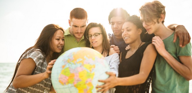 Diverse Group of Students Gathering round a Globe