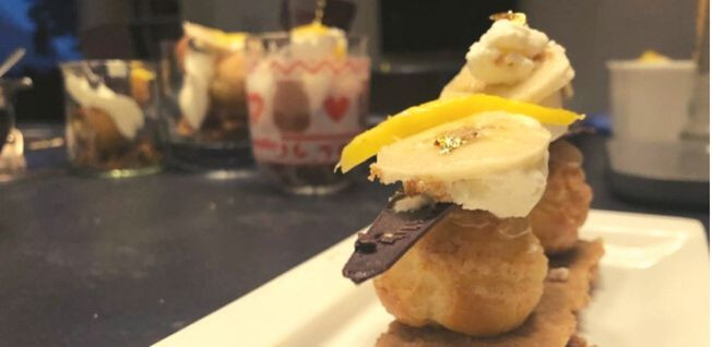 Close-up of a plate with a French puff pastry cake with caramel, cream, chocolate, and banana