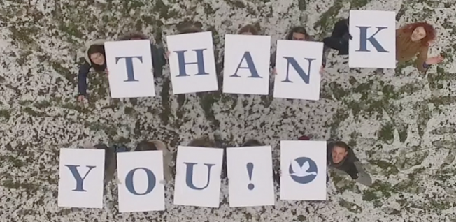 Group of People Holding Up Thank You Signs from Above