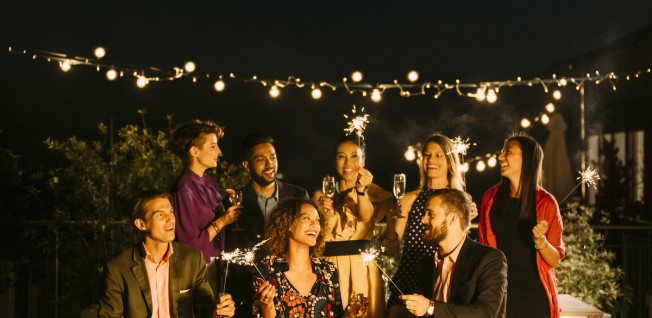 Group of People at Party Lighting Sparklers in the Dark