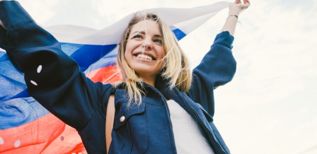 blonde young woman cheering under russian flag
